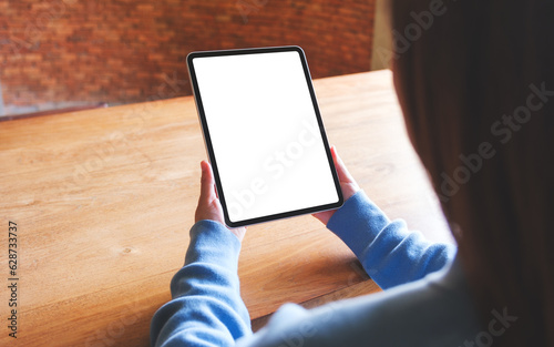 Mockup image of a woman holding digital tablet with blank white desktop screen