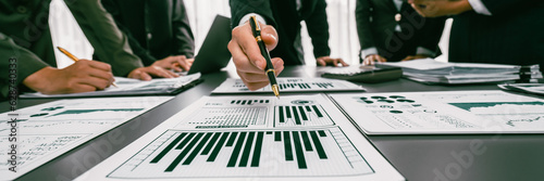 Analyst team working on BI Fintech to analyze financial dashboard paper at office workplace. Businesspeople reviewing report paper on table for business insight. Panorama shot. Prodigy