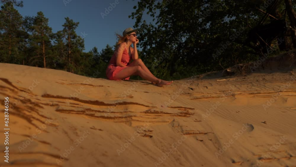 Meditation girl sits on the sand and looks at the sunrise or sunset Meditation girl sits on the sand and looks at the sunrise or sunset
