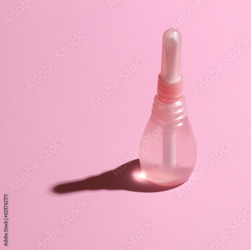 Vaginal enema on a pink background. Women's health photo