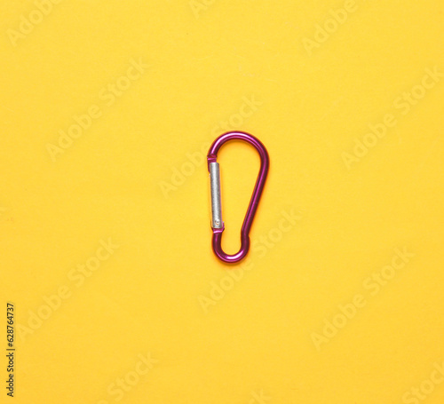 Metal carabiner on a yellow background