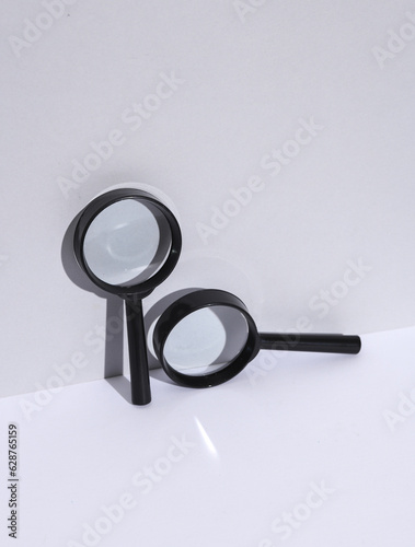 Magnifying glass on white background with shadow. Creative layout. Minimal business concept. Conceptual still life