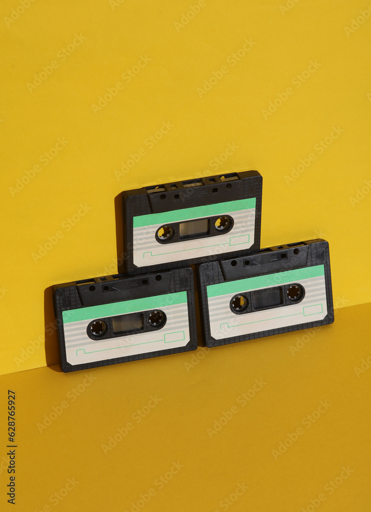 Obraz premium Retro 80s audio cassettes on yellow background with shadow. Creative layout, minimalism, music lover