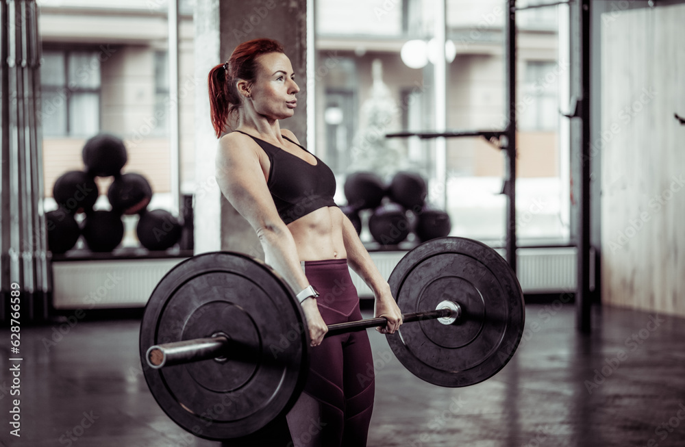 Athletic woman training deadlift with heavy barbell in modern gym. Healthy lifestyle Athletic woman training deadlift with heavy barbell in modern gym. Healthy lifestyle