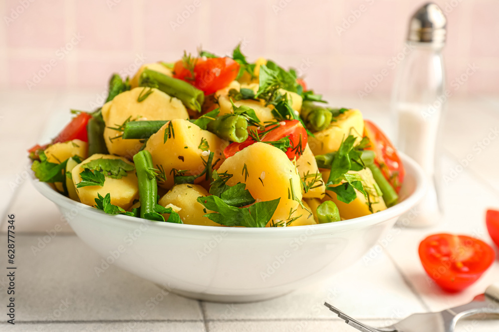 Bowl of tasty Potato Salad with vegetables on table, closeup
