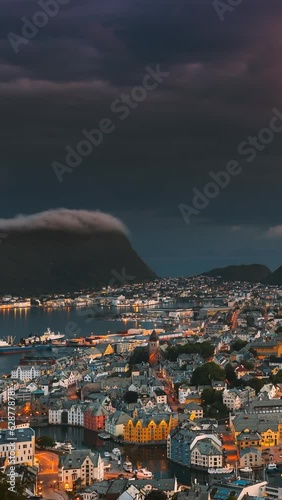 Alesund, Norway. Day To Night Time-lapse. Dramatic Sky In Warm Colours Above Alesunds Islands In Sunset Time. . Famous Town In Evening Night Time. Vertical, Vertical Shot, Vertical Video, photo