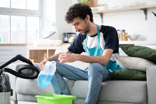 Young man pouring detergent...