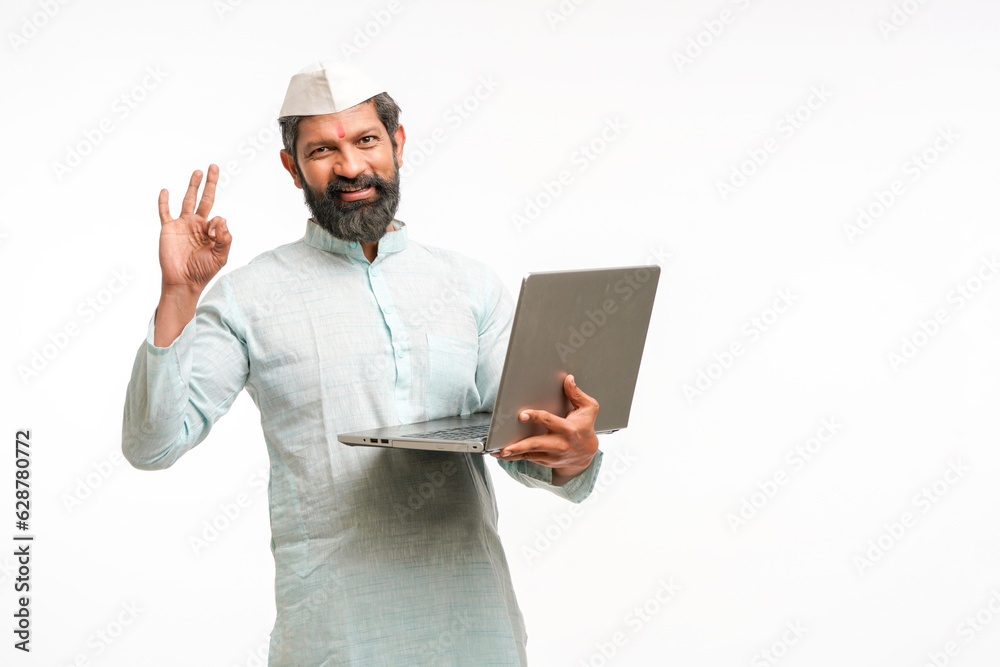 Indian man in traditional wear and using laptop on white background. Indian man in traditional wear and using laptop on white background.