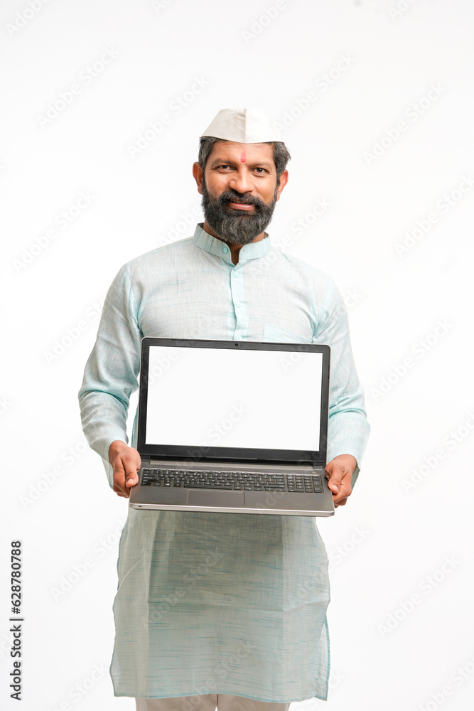 Indian man in traditional wear and showing laptop screen on white background. Indian man in traditional wear and showing laptop screen on white background.