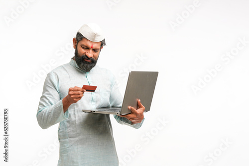 Indian man using laptop and bank card on white background.