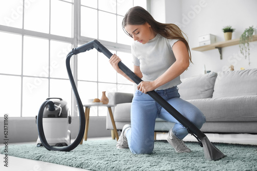 Young woman cleaning living...