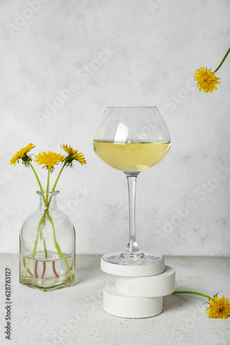 Glass of dandelion wine on white table