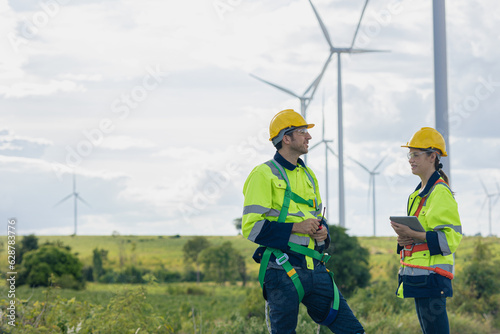 Engineer team man and woman field working together survey plan construction wind turbine clean power generator