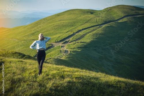 Beautiful Young Fitness Girl with Blonde Hair Posing in High Carpathian Mountains