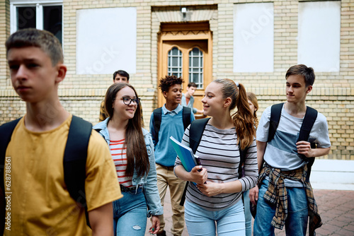 Photography Happy teenage girls talk while getting out of high school building with their classmates