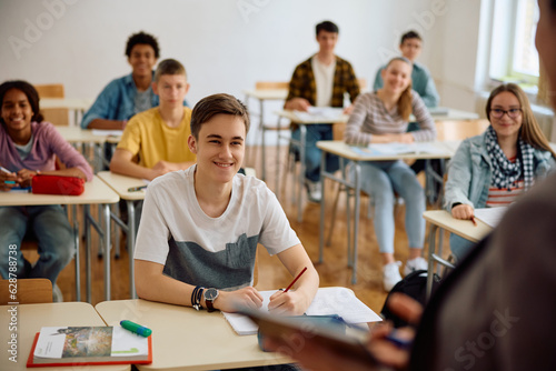 Group of students listening teacher's lecture during class at high school. © Drazen