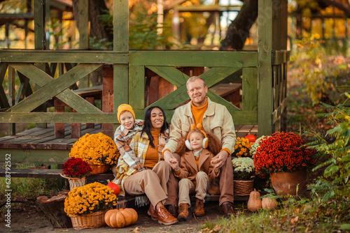 family traditions. multiethnic family i am in autumn in the park in a wooden gazebo next to pumpkins and flowers