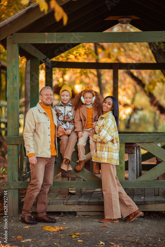 multiethnic family on a walk in the autumn park in a wooden gazebo