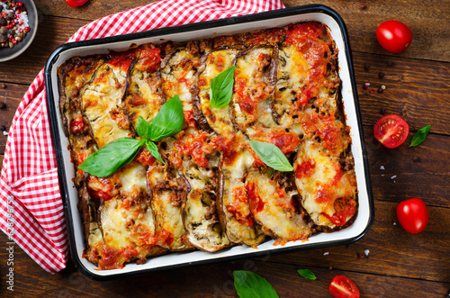 Eggplant Casserole, Roasted Eggplant Dish with Minced Meat, Tomato Sauce and Mozzarella over Rustic Background