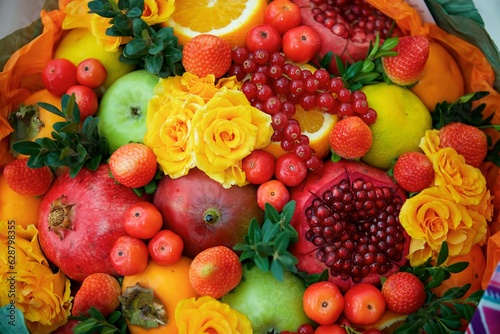 A bouquet of flowers and different fruits. A bright and original gift from florists