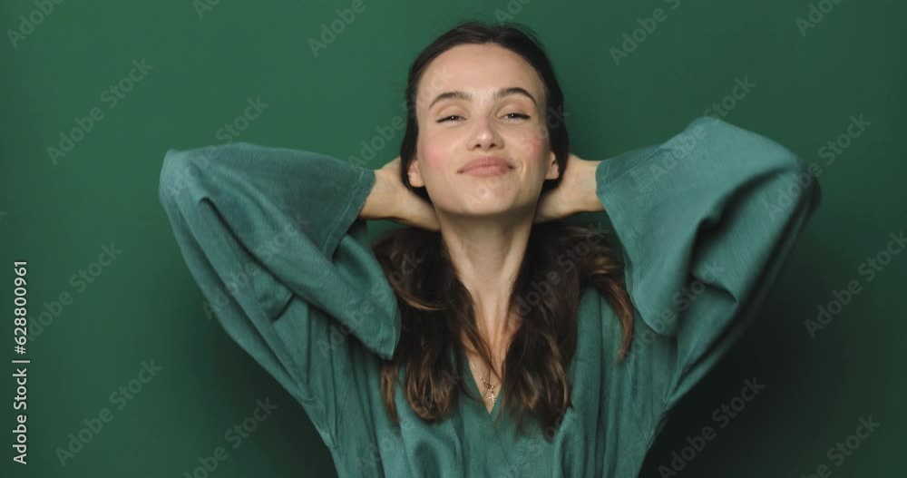 Lovely coquettish brunette woman, winking playfully, make hello gesture, flirting. Woman fix her hair isolated green studio. Curly hair fashion model face smiling. Girl look around, waving her hand. Lovely coquettish brunette woman, winking playfully, make hello gesture, flirting. Woman fix her hair isolated green studio. Curly hair fashion model face smiling. Girl look around, waving her hand.