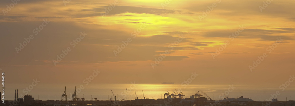 Strand von Livorno in Italien mit Industriehafen bei Sonnenuntergang Abendrot