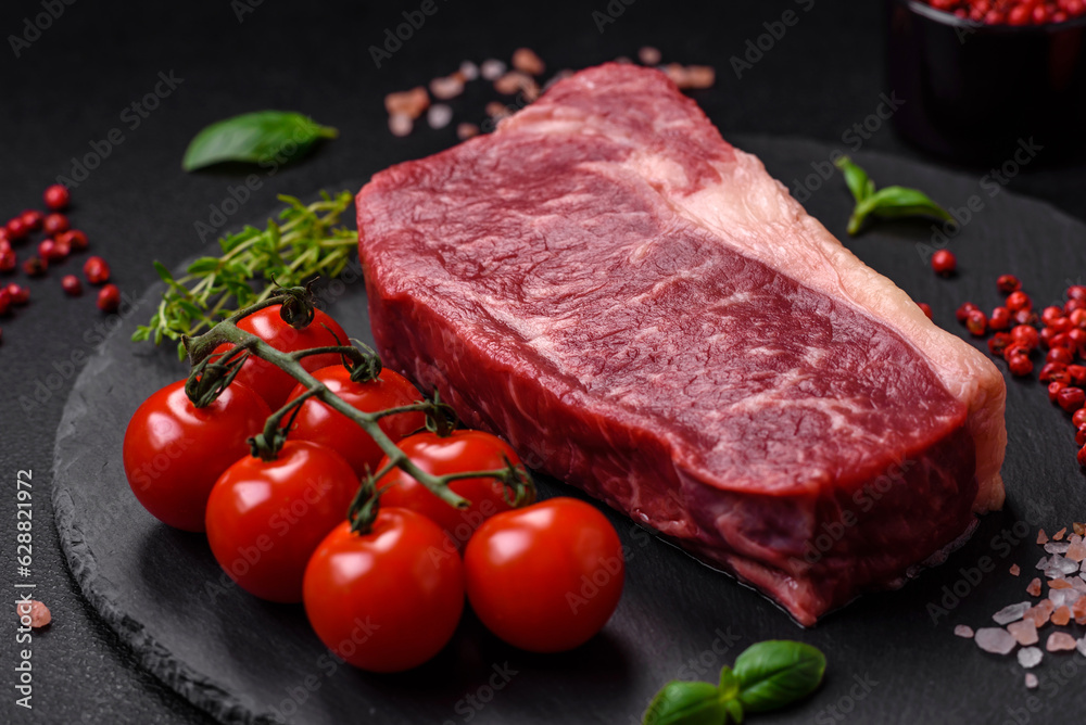 Fresh raw beef striploin steak with salt, spices and herbs