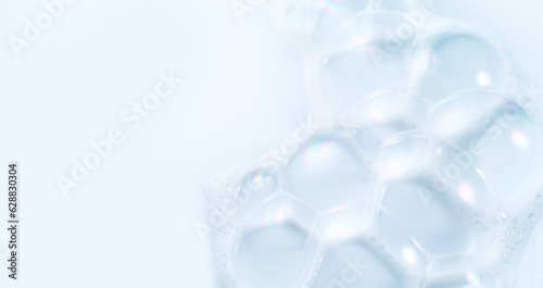 Foam border design on blue background. Liquid soap bubbles, Foam bubbles background. Soap foam popping bubble, white backdrop. Soap sud macro structure. Soap foam close-up. Clean, cleaning, washing.