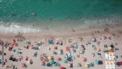 Footage 4k 25Fps: aerial view from the drone of the beach of Tropea in Calabria with the crystalline Caribbean sea, the bathers and the colored umbrellas. The video conveys a sense of peace and sereni