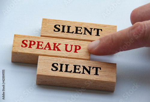 Finger pushing wooden block with red written text speak up. Courage and speak up concept photo