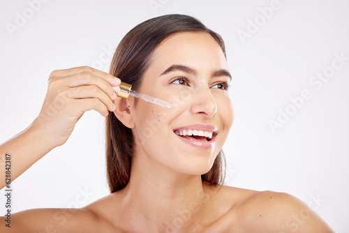 Facial skincare, smile and woman with a serum, cosmetics or happiness on a white studio background. Female person, model or girl with essential oil, retinol product or dermatology with natural beauty