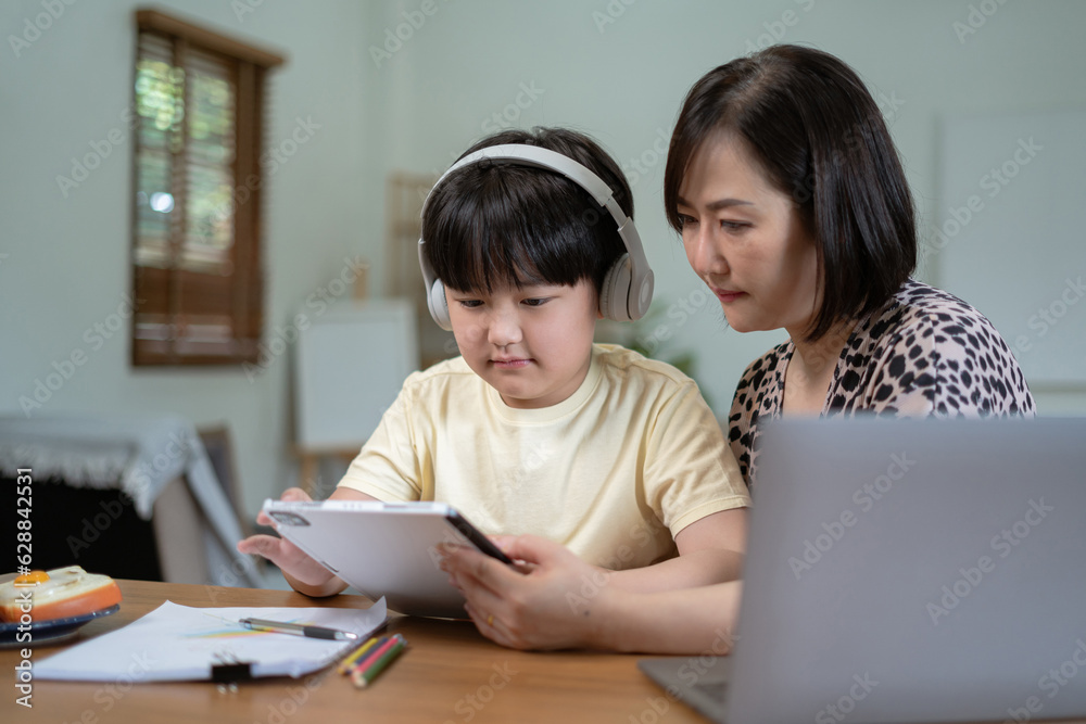 Parents helping children with homework at table at home. Parents helping children with homework at table at home.