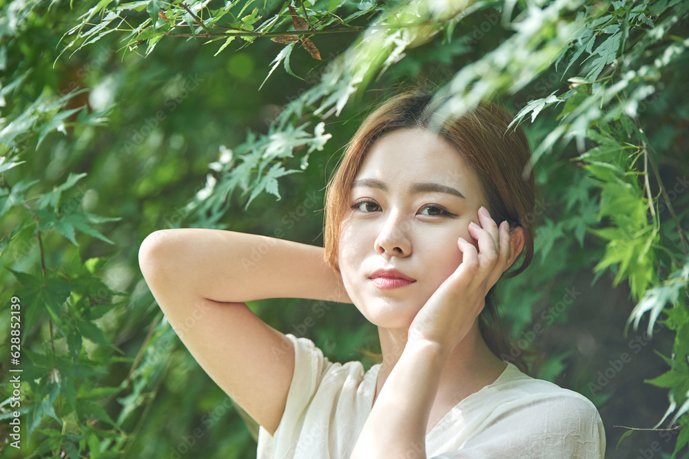 In summer daytime, a beautiful Asian woman wearing a dress in a forested park is doing various movements. In summer daytime, a beautiful Asian woman wearing a dress in a forested park is doing various movements.