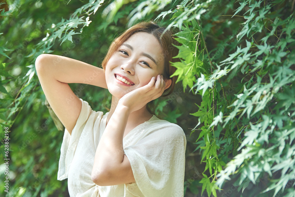 In summer daytime, a beautiful Asian woman wearing a dress in a forested park is doing various movements. In summer daytime, a beautiful Asian woman wearing a dress in a forested park is doing various movements.
