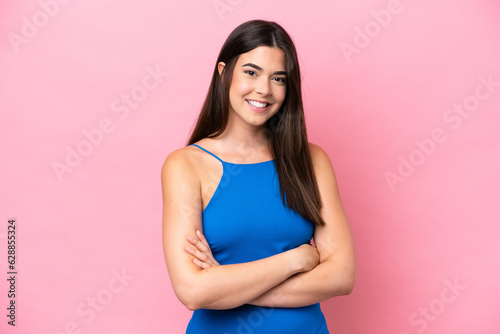 Young Brazilian woman isolated on pink background keeping the arms crossed in frontal position