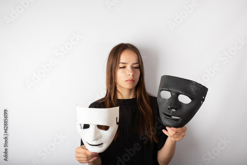 Cuadro en lienzo mask black and white in the hands of a young woman, split personality,psychology