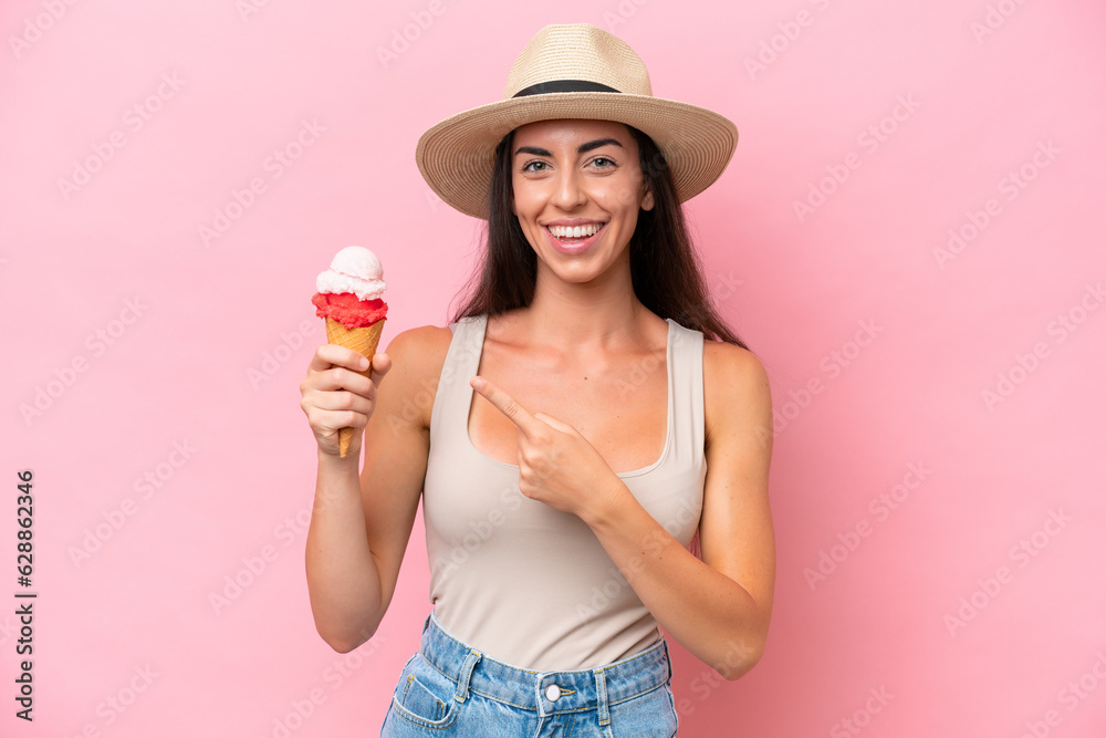 Young caucasian woman with a cornet ice cream isolated on pink background pointing to the side to present a product Young caucasian woman with a cornet ice cream isolated on pink background pointing to the side to present a product