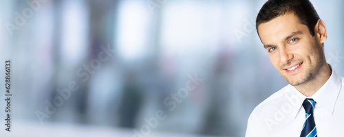 Portrait of happy smiling young brunette businessman in white shirt and tie, over blurred modern office interior background with copy space. Confident business man indoors. Free Download Portrait of happy smiling young brunette businessman in white shirt and tie, over blurred modern office interior background with copy space. Confident business man indoors. - GFXLoad