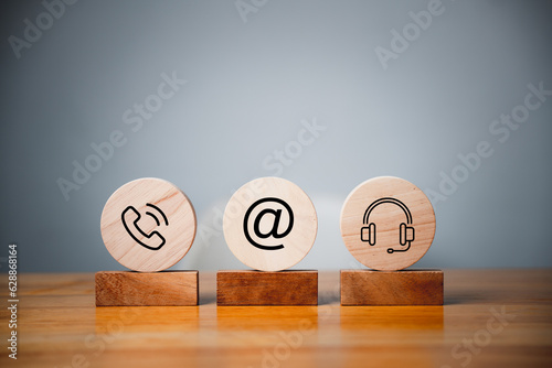 Contact us concept on website page. Customer support hotline and people connection. Wood label circle with email, phone, address, chat message, and headset icons. Business communication banner.