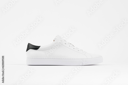 White sneaker product shot. Unbranded classic white sneakers side view.