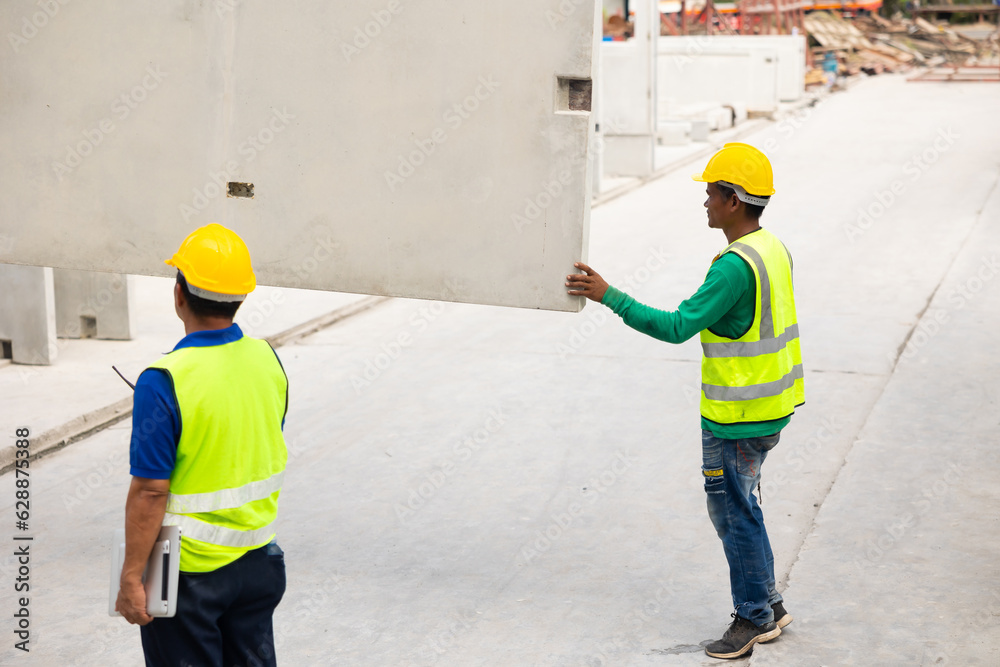 Reinforced concrete structures. Man construction worker control large crane for placing precast concrete panels at Heavy Industry Manufacturing Factory