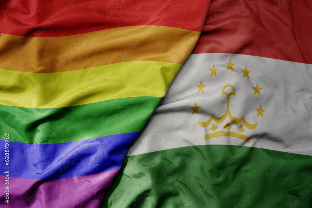 Fototapeta premium big waving realistic national colorful flag of tajikistan and rainbow gay pride flag .
