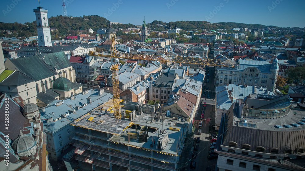 The yellow construction crane is working. View from above. Lviv, Ukraine