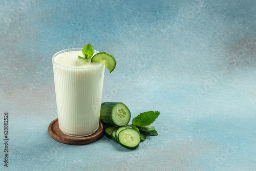 Homemade yogurt drink Ayran with fresh cucumber on a blue background, clean eating for weight loss. place for text
