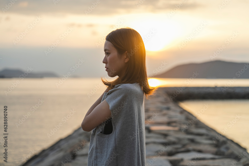 夕暮れの海にいる女性
