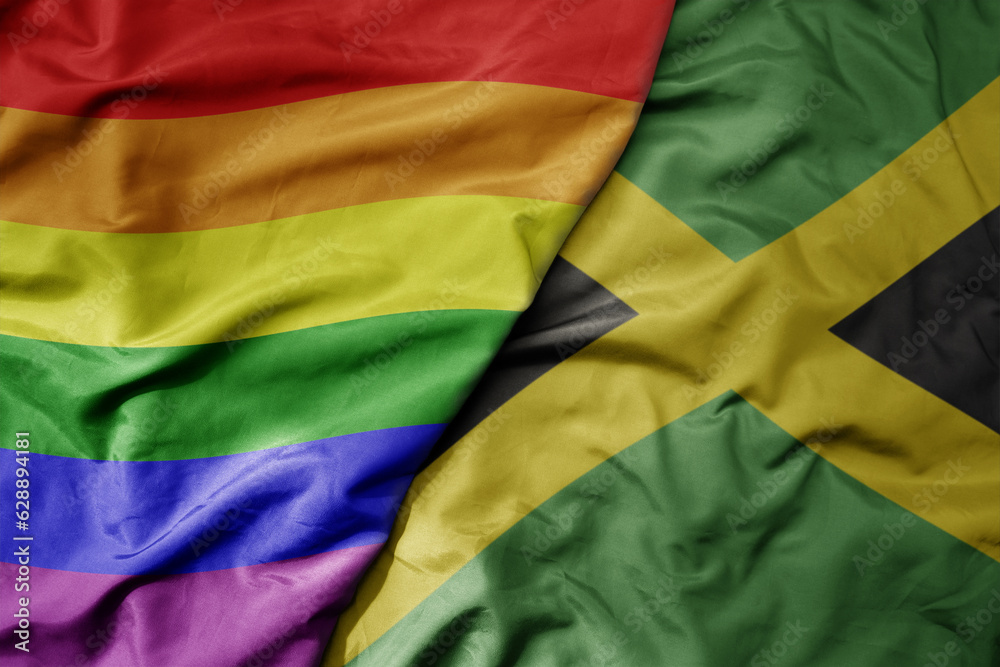 Obraz premium big waving realistic national colorful flag of jamaica and rainbow gay pride flag .