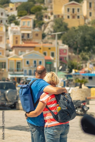 Couple embracing in a warm and affectionate hug while standing on a sidewalk surrounded by houses