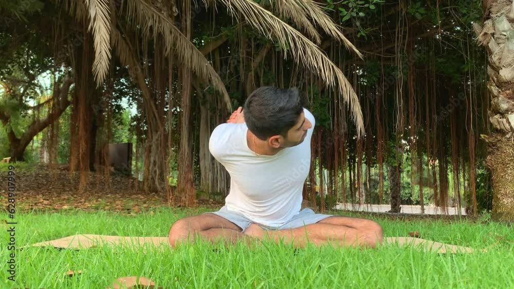 Joven indio entrenando yoga. Sesión de fitness en colchoneta en el parque. Relax al aire libre para una buena salud. Ejercicios para una mejor movilidad por las mañanas en verano en canarias. 