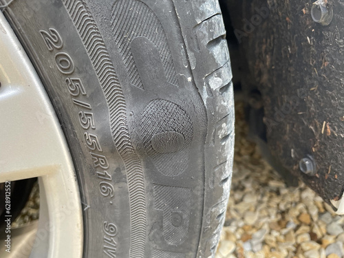 Newcastle UK: 8th July 2023: close-up of a damaged car tyre with a large bulge and perished rubber