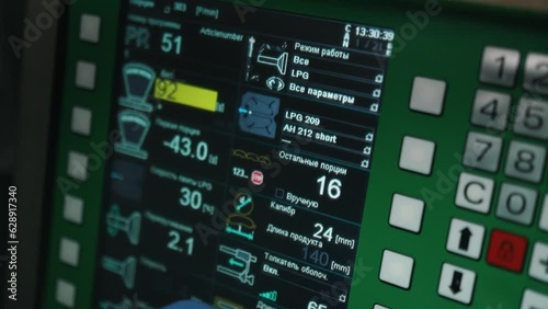Modern meat production line. The worker's hand controls equipment using the buttons on machine. Preparation and kneading of minced meat and sausages. Industrial Meat Processing Plant